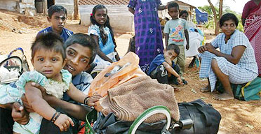 Villagers get ready to evacuate with their belongings to a refugee camp in Sri Lanka