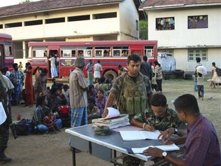 Sri Lankan army soldiers register the ethnic Tamil civilians who escaped from the war zone and arrived at a transit camp at Vavuniya, Sri Lanka, Wednesday, Feb. 11, 2009.