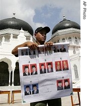 A man displays a sample ballot during an election simulation in front of the main mosque in Banda Aceh, 6 Dec. 2006<br />