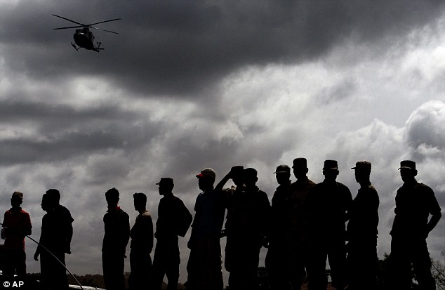 Daily Mail, May 25, 2009 Military and local people watch as a UN helicopter lands at the camp