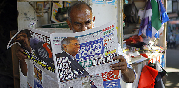 A Sri Lankan man reads a newspaper carrying news on this week's parliamentry elections. Pic: AP.