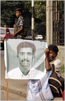 man holds a poster of a missing relative