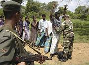 A soldier soldier searches ethnic Tamils  moving from Tamil rebel territory in  Vavuniya to government-controlled areas  February 20, 2007.  REUTERS/Stringer    (SRI LANKA) 