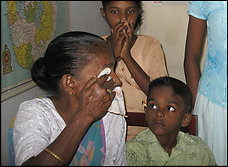 Grandchildren comfort G.H. Mithralatha, 75, a Tamil whose son was taken by police.