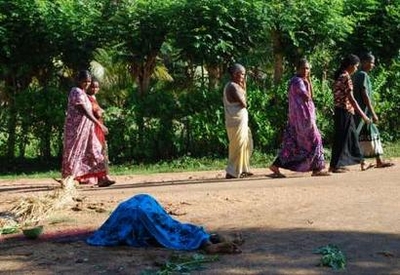 Ethnic Tamil women walk past the site where thirty-three-year-old ...