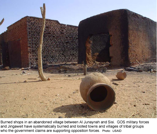 Burned shops in an abandoned village between Al Junaynah and Sisi.