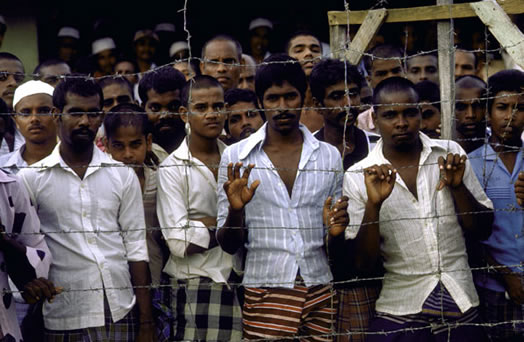 Boosa, 1986: Young prisoners stare out from behind a barbed wire fence at a government detention camp for suspected Tamil separatist rebels