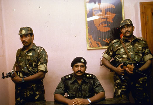 Sri Lanka, 1987: The LTTE leader, Velupillai Prabhakaran, sits flanked by two Indian guards below a picture of guerilla fighter Ché Guevera