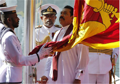 Sri Lankan President Mahinda Rajapaksa, center, hoists the national flag,
