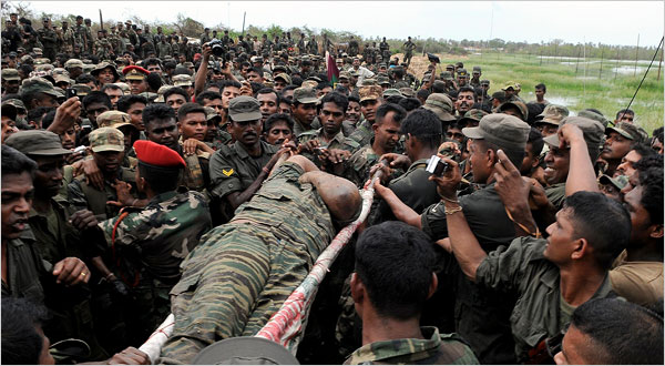 A body identified as that of the Tamil rebels’ leader, Vellupillai Prabhakaran, was carried Tuesday through Sri Lankan troops. [Reuter photo: New York Times, May 20, 2009] 
