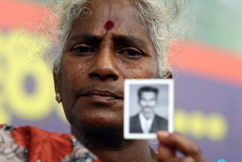 Senevirathnam Wasanayagi 63, relative of a detained Tamil Tiger rebel suspect cries as she holds up a photo of her son during a protest outside the main prison on May 29, 2012 in Colombo, Sri Lanka. 