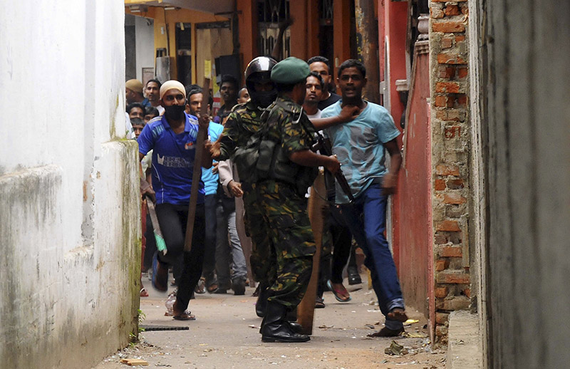 Special Task Force soldier blocks a Muslim man outside a vandalized mosque in Colombo. PHOTO: Reuters