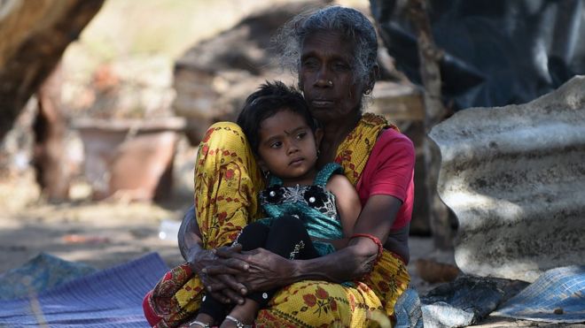 A Sri Lankan Tamil woman and child look on in the eastern town of Muttur on August 22, 2015. Sri Lankan President Maithripala Sirisena visited the region to return land to some 205 families whose properties were occupied by security forces during the Tamil separatist war that ended in May 2009.